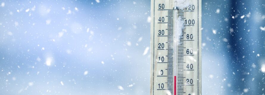 Thermometer on snow shows low temperatures - zero. Low temperatures in degrees Celsius and fahrenheit. Cold winter weather - zero celsius thirty two farenheit.